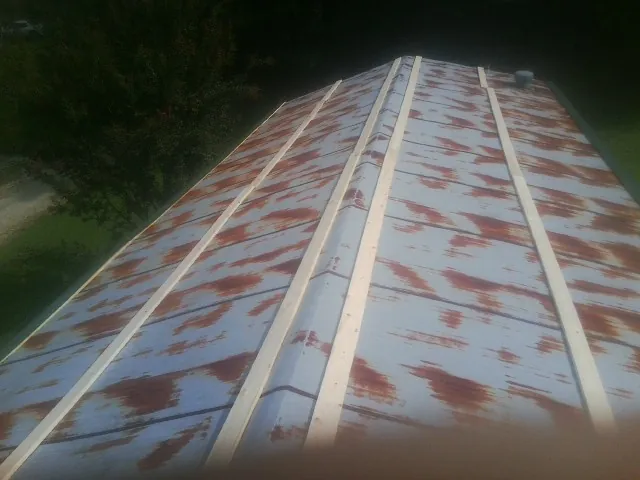 Rusted metal roof panels with new wood purlins before replacement — Storm Damage Roof Repair in Westfield by Roofing Brothers