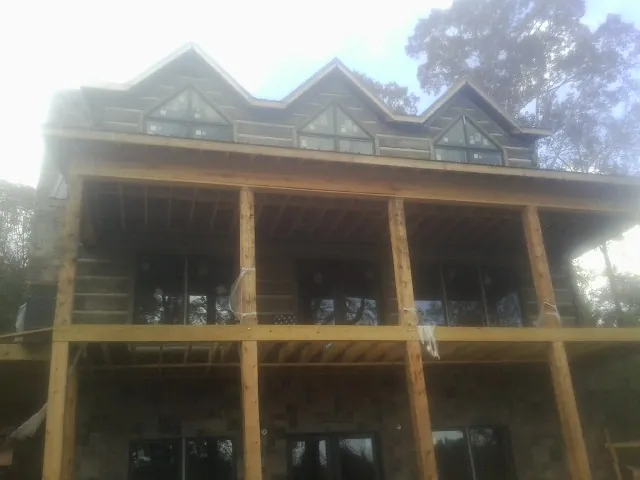 Dormers and porch framing on a large log home under construction — Roof Coating work by our crew in Westfield